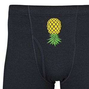 May include: Black boxer shorts with a yellow pineapple graphic print.