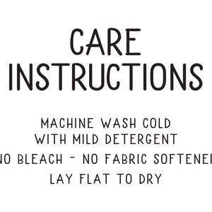 May include: Black and white text on a white background with the words "CARE INSTRUCTIONS" in a large font. The text below reads "MACHINE WASH COLD WITH MILD DETERGENT NO BLEACH - NO FABRIC SOFTENER LAY FLAT TO DRY."