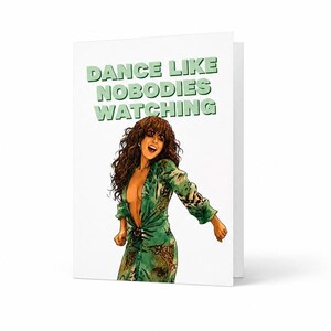 May include: A white greeting card featuring the text DANCE LIKE NOBODIES WATCHING in light green letters above an illustration of a person with long brown hair wearing a green patterned dress with a deep neckline, shown in a dynamic pose.