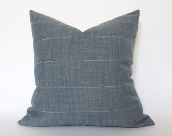 May include: A blue and white striped throw pillow with a soft, textured fabric. The pillow is square and has a simple design.