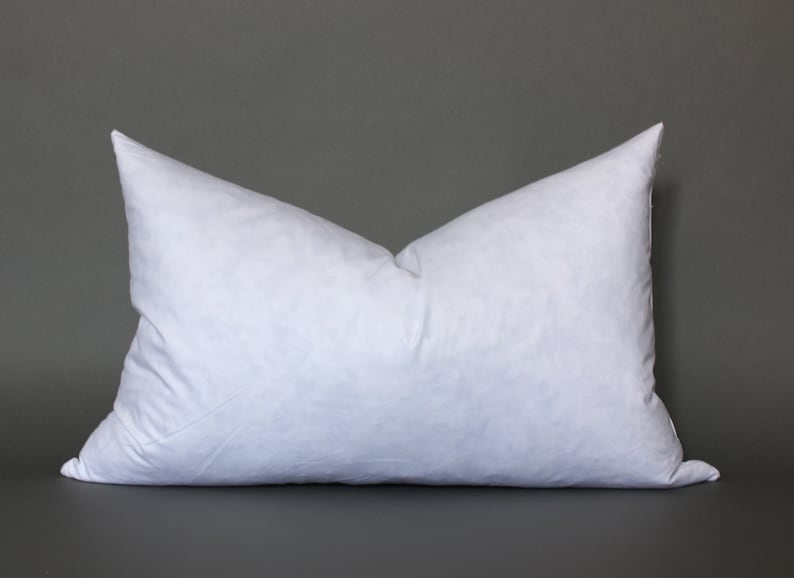 Puede incluir: Una almohada blanca con una textura suave y esponjosa. La almohada es rectangular y tiene una superficie lisa y uniforme.