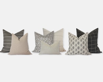 May include: A set of six decorative throw pillows with various patterns and colors, including beige, brown, and black. The pillows are made of linen and feature a variety of designs, such as stripes, floral prints, and geometric patterns.