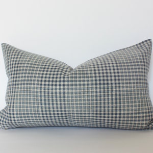 Puede incluir: Una almohada de gingham azul y blanco con una tela suave y texturizada.