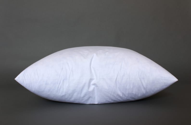Puede incluir: Una almohada blanca con una textura suave y similar al algod&oacute;n. La almohada est&aacute; rellena y parece estar llena de un material suave.