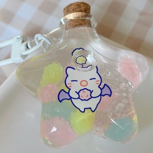 May include: A star-shaped glass bottle with a cork stopper, filled with colorful gel beads. The bottle features a cartoon character illustration. A white clip is attached to the bottle.