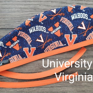 May include: A navy blue and orange scrub cap featuring the text "WAHOOS" and "VIRGINIA" with the University of Virginia logo. The cap has an orange trim and ties.