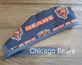 May include: Navy blue surgical scrub cap featuring the Chicago Bears logo and the word "BEARS" in orange. The cap has a gray trim and a matching tie. The text "Chicago Bears" is written in white.