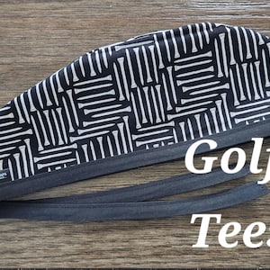 May include: Black and white patterned surgical scrub hat with a black elastic band and the text "Golf Tees".