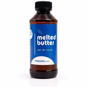 May include: A brown plastic bottle with a black screw-top cap and a blue label. The label features the text "melted butter" and "NET WT. 4 FL. OZ" along with the website "PKBAKES.com" and a small graphic of butter sticks.