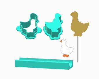 May include: A collection of goose-themed items. Features two teal goose-shaped cookie cutters, a gold goose-shaped lollipop, a white goose illustration with orange feet and beak, and a teal rectangular mold.