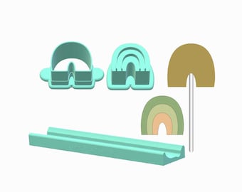 May include: A selection of teal rainbow-shaped cookie cutters and a matching rectangular tool. The cutters include a single arch, a multi-layered arch, and a two-part design. Also included are two rainbow-shaped cutouts in shades of green, tan, and peach.