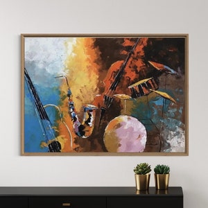 May include: A framed abstract painting of musical instruments in a colorful style. The painting features a saxophone, a cello, and a drum set. The colors in the painting are mostly warm tones, including orange, yellow, red, and brown. The painting is hanging on a white wall above a black dresser with gold handles.