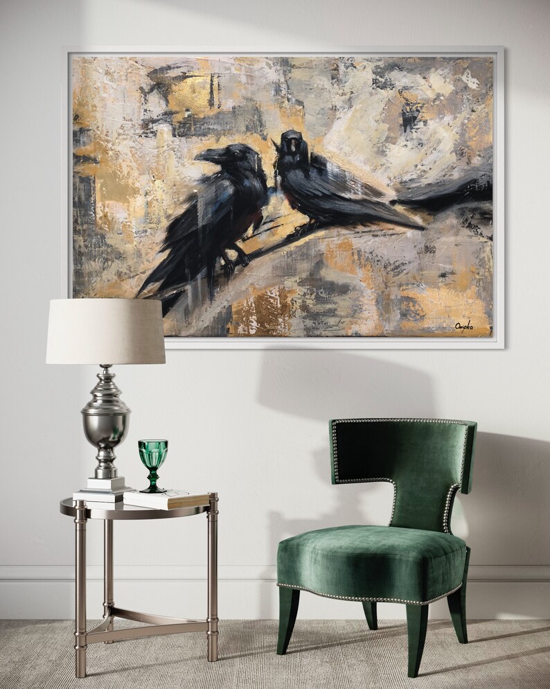 Puede incluir: Pintura abstracta de dos cuervos negros posados en una rama, con un fondo dorado y gris. La pintura est&aacute; enmarcada en un marco blanco.