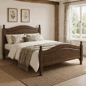 May include: A dark wooden bed with a curved headboard and footboard. The bed is dressed with white bedding, floral pillows, and a beige throw. A woven rug is placed on the floor beneath the bed. The room has a rustic feel.