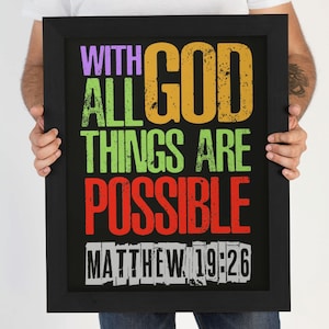 May include: A black framed poster with the text "With God All Things Are Possible" in colorful, distressed lettering. The text "Matthew 19:26" is printed below in white.