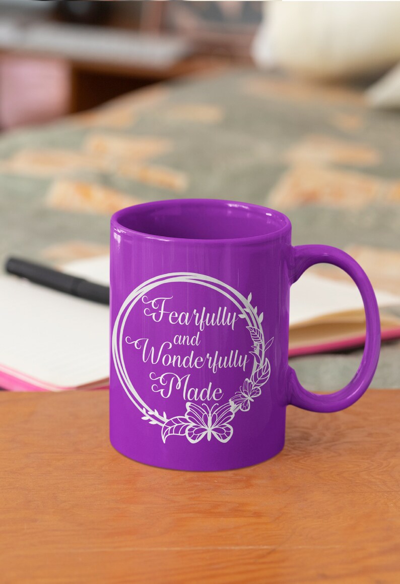 May include: Purple ceramic mug with a white design that says "Fearfully and Wonderfully Made" in a circle with floral accents and butterflies.