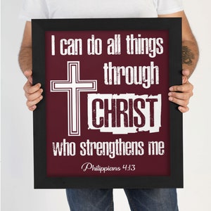 May include: A framed print with a maroon background and white text that reads "I can do all things through CHRIST who strengthens me Philippians 4:13". A white cross is centered above the text.
