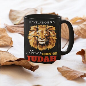 Może przedstawiać: Czarny kubek ceramiczny z grafiką głowy lwa i tekstem "Revelation 5:5 Jesus Lion of Judah".