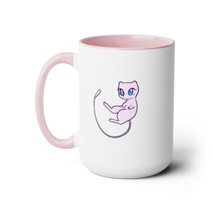 May include: A white ceramic mug with a pink rim and handle. The mug features a cartoon illustration of a pink, cat-like Pokemon with blue eyes.