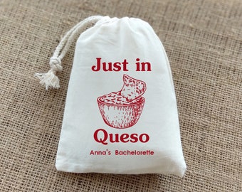 May include: White drawstring bag with red text that says "Just in Queso Anna's Bachelorette" and a drawing of a bowl of queso dip with a tortilla chip dipping in.