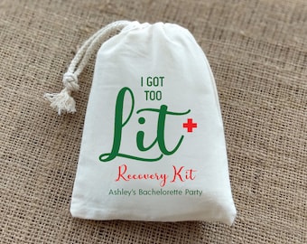 May include: White drawstring bag with the text "I got too lit" in green with a red plus sign. The text "Recovery Kit" is in red and the text "Ashley's Bachelorette Party" is in black.