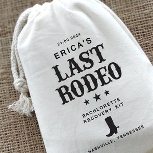 May include: White cotton drawstring bag with black text that reads "21.09.2024 Erica's Last Rodeo". Three black stars are below the text. Below the stars is the text "Bachelorette Recovery Kit" and a black silhouette of a cowboy boot. Below the boot is the text "Nashville, Tennessee".