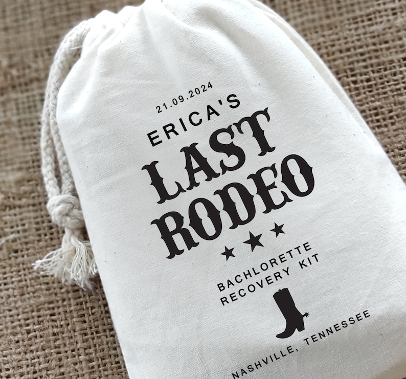 May include: White cotton drawstring bag with black text that reads "21.09.2024 Erica's Last Rodeo". Three black stars are below the text. Below the stars is the text "Bachelorette Recovery Kit" and a black silhouette of a cowboy boot. Below the boot is the text "Nashville, Tennessee".