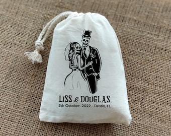 May include: White cotton drawstring bag with a black and white illustration of a skeleton bride and groom. The text "Liss & Douglas 5th October, 2022 - Destin, FL" is printed below the illustration.