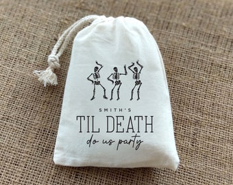 May include: White cotton drawstring bag with three black skeleton figures dancing and the text "Smith's Til Death do us party".
