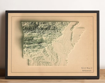 Könnte beinhalten: Eine Reliefkarte von Arkansas im Vintage-Stil, in Schwarz gerahmt. Die Karte ist auf cremefarbenem Papier gedruckt, mit grüner und brauner Schattierung, um die Topographie des Bundesstaates zu zeigen. Der Text "Relief Map of Arkansas" ist in der unteren rechten Ecke gedruckt.