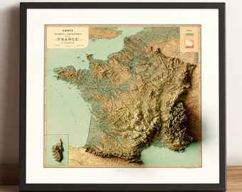 Puede incluir: Un mapa en relieve de Francia de estilo vintage, que muestra la topografía del país y los principales ríos. El mapa está enmarcado en negro y tiene un fondo verde claro con acentos marrones y beige.