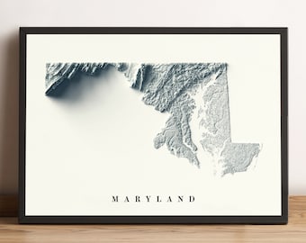 May include: A black framed print of a topographic map of Maryland. The map is in shades of blue and grey, with the state's name printed in black at the bottom.