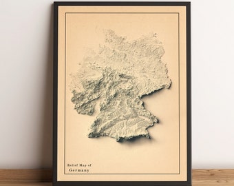 May include: A framed relief map of Germany with a beige background and a black frame. The map shows the topography of the country with raised areas representing mountains and valleys.