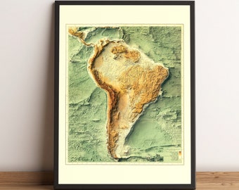 Puede incluir: Un mapa en relieve de estilo vintage de América del Sur, que muestra la topografía del continente con tonos de verde, marrón y amarillo. El mapa está enmarcado en negro y tiene un passe-partout blanco.