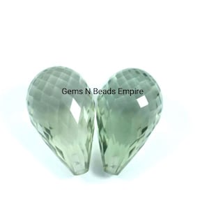 May include: Two green gemstone teardrop beads with faceted surfaces. Gems N Beads Empire.