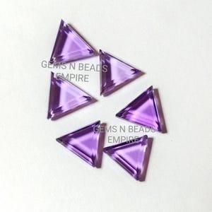 May include: Six purple triangle-shaped gemstones. The gemstones are faceted and have a shiny finish.  Gems N Beads Empire.