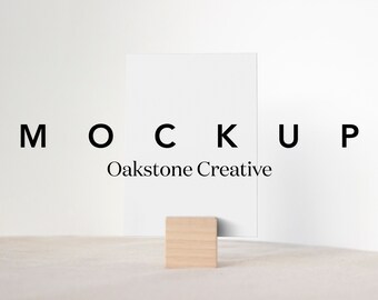 May include: A white card mockup with the text "MOCKUP" and "Oakstone Creative" on a white background. The card is standing on a small wooden block.