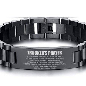 May include: Black stainless steel bracelet with a silver plaque engraved with the "Trucker's Prayer". The prayer reads: "Please help me to be safe as I travel each mile. Let your presence guide me and bring me a smile. Take care of my family while I am away. Let them know I miss them each and every day. Steer me clear of danger as I drive these miles alone. I put my hands in yours, Lord. Keep me safe. Get me home."