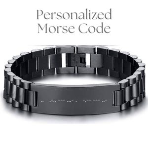 May include: A black stainless steel bracelet with a Morse code design. The bracelet features a rectangular plate in the center with the Morse code dots and dashes. The text "Personalized Morse Code" is at the top of the image.