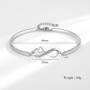 a silver bracelet with a heart and an arrow on it