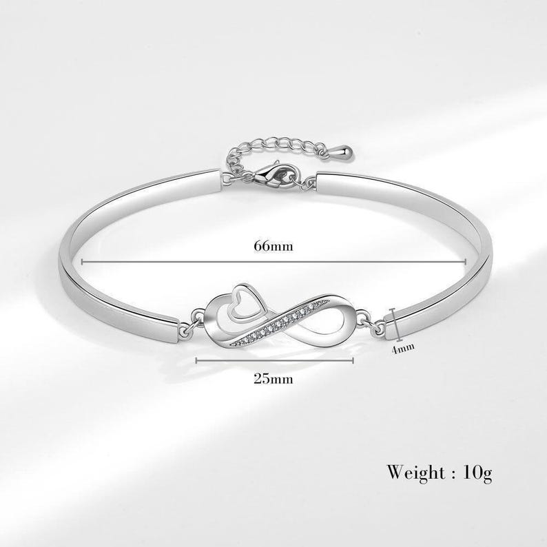 a silver bracelet with a heart and an arrow on it