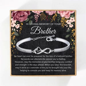 May include: A silver bracelet with an infinity charm and the words "I love you" and "12.10.2021" engraved on it. The bracelet is in a box with a floral design and the words "In loving memory of your brother".