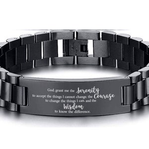 May include: Black stainless steel bracelet with an engraved message: "God, grant me the Serenity to accept the things I cannot change, the Courage to change the things I can, and the Wisdom to know the difference."
