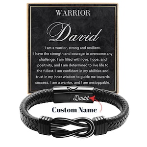 May include: Black braided leather bracelet with a stainless steel clasp. The bracelet features a decorative knot design and the text "Custom Name". A card in the background reads "WARRIOR" and includes inspirational text.