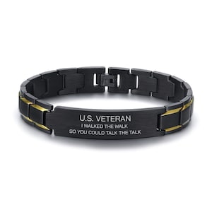 May include: Black and gold stainless steel bracelet with a black plate engraved with the text "U.S. VETERAN I WALKED THE WALK SO YOU COULD TALK THE TALK"