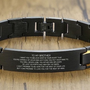 May include: Black and gold stainless steel bracelet with an engraved message that reads "To my brother, I want you to believe deep in your heart that you're capable of achieving anything you put your mind to. You will never lose, you either win or learn. So just go forth and aim for the skies. I can't promise to be here for the rest of your life, but I can promise to love you for the rest of mine."