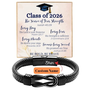 May include: A black braided leather bracelet with a stainless steel clasp. The bracelet features a knot design and the name "Ethan" is engraved on the clasp. A graduation-themed card with text that reads "Class of 2026" is in the background.