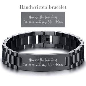 May include: A black stainless steel bracelet with a rectangular tag engraved with the text "You are the best thing I've done with my life - Mom".