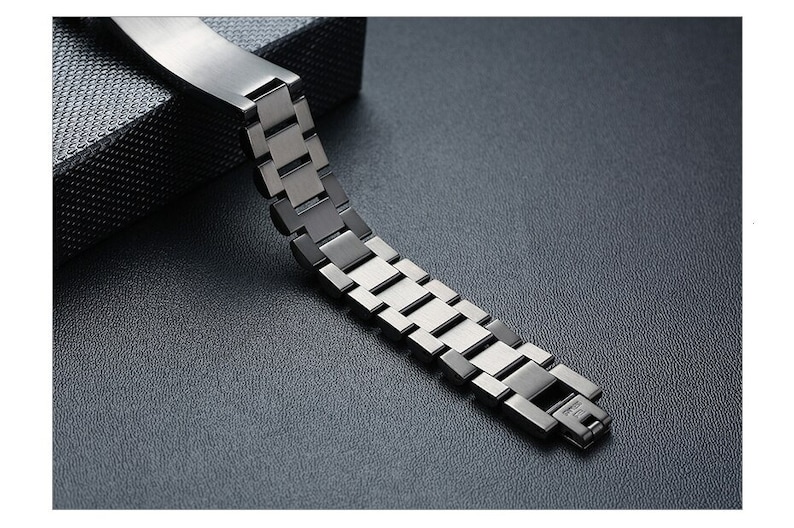 May include: A silver metal watch band with a link style design. The band is made of multiple connected links.