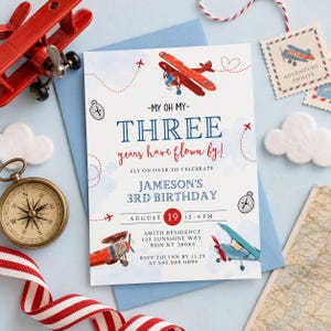 May include: A birthday invitation card featuring watercolor illustrations of red and blue airplanes, a compass, and dashed flight paths. The text reads: My oh my, three years have flown by! Fly on over to celebrate Jameson's 3rd birthday, August 19, 12-4 PM.